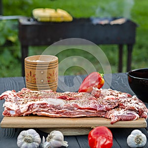 Fresh pork ribs in marinade lie on a chopping board before grilling