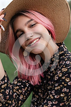 Fresh portrait pretty cheerful young woman with perfect positive smile with pink hair in fashionable straw hat in stylish black