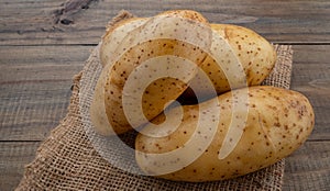 Fresh potato on wood background, organic food