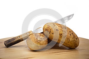 Fresh potatoes and knife isolated on white