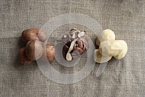 Fresh potatoes on linen canvas background. Four peeled potatoes and a peel. Top view