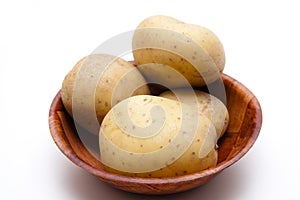 Fresh potatoes in wooden bowl