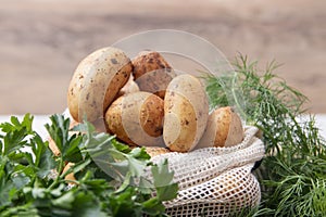 Fresh potatos in potato bag after harvest, dill, parsley, top view