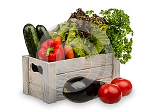 Fresh potted lettuce, mint ,parsley, carrots, paprika and zucchini in wooden box isolated.