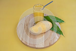 Fresh premium mango variety of Thailand called Nam Dok Mai on a wooden plate. 