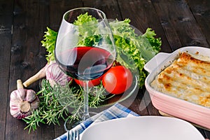 Fresh prepared lasagne with ingredients on table