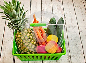 Fresh produce in a green basket on a wooden tabletop