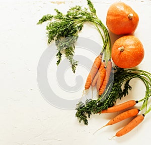 Fresh pumpkin and carrot on white vintage background closeup