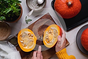 Fresh pumpkin. Cutting pumpkin in slices on cutting board, female hands preparring autumn foods. Baked squash or