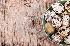 Fresh quail eggs on a wooden board. Vegetarian diet. Copy space.