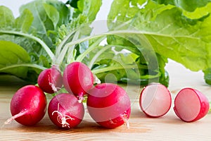 Fresh radishes, Raphanus sativus, on wooden plate