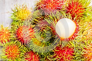 Fresh rambutans on wooden background. Tropical fruit.