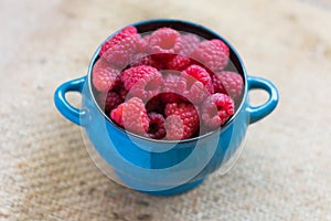 Fresh raspberries in a blue bowl