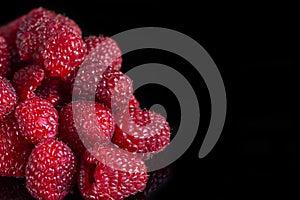 Fresh raspberries close up on a black background. Selective focus