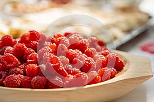 Fresh raspberries on a wooden plate detail macro photography