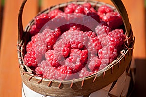 Fresh raspberry in a basket on wooden table
