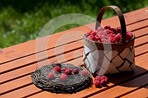 Fresh raspberry in a basket on wooden table