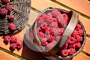 Fresh raspberry in a basket on wooden table