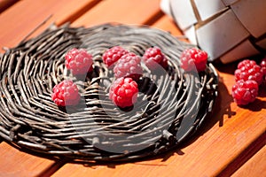 Fresh raspberry in a basket on wooden table