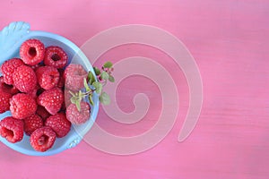fresh raspberry in blue bowl,on colored background, negative space technique, free copy space