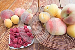 Fresh raspberry, peaches and Apricot in a wicker basket on wooden table