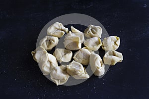 Fresh Ravioli on floury dark background. Italian homemade healthy food concept.Process of making italian ravioli