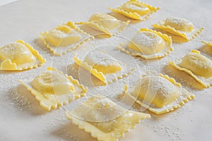 Fresh ravioli pasta durind cooking on light background