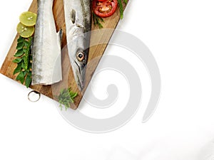 Fresh raw Barracuda Fish (cheelavu) head and body decorated with herbs and vegetables .