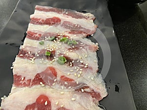 Fresh raw beef brisket slice set on the black dish.