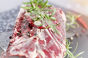 Fresh raw beef flank steak sprinkled with spices, rosmairin and chilli pepper photo