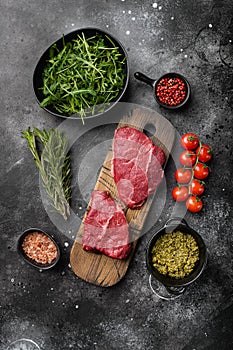 Fresh raw Beef meat Rump Steak, on black dark stone table background, top view flat lay