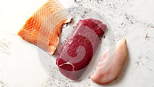 Fresh raw beef steak, chicken breast, and salmon fillet