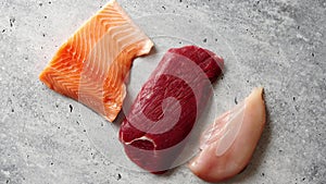 Fresh raw beef steak, chicken breast, and salmon fillet