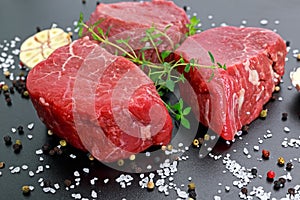 Fresh Raw Beef steak Mignon, with salt, peppercorns, thyme, garlic Ready to cook