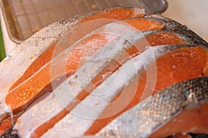 Fresh and raw big salmon fish was cut into pieces at the Tsukiji fish market, Japan..Fresh tuna