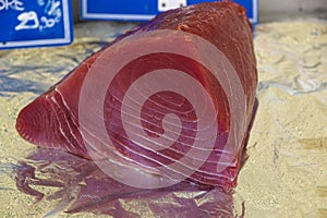 Fresh and raw big tuna fish was cut into pieces by the expert fishmonger for showing to the customer at the fresh and