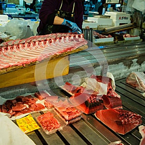 Fresh and raw big tuna fish was cut into pieces by the expert fishmonger for showing to the customer at the fresh and