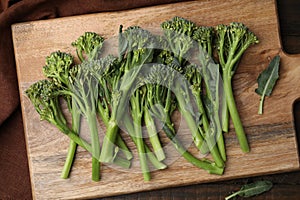 Fresh raw broccolini on wooden board, top view. Healthy food