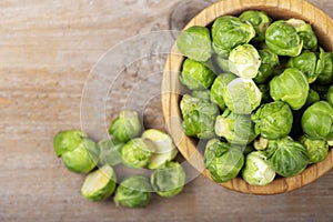 Fresh raw brussels sprouts in a bowl on a wooden table