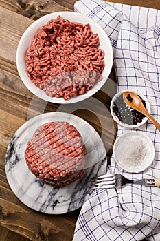 Fresh raw burger patty on marble