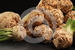 Fresh raw celery roots on black table, closeup