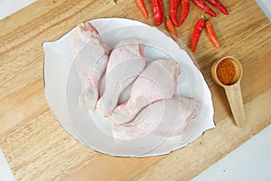 Fresh Raw Chicken Drumstick on a White plate and seasoning