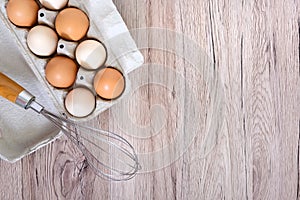 Fresh raw chicken eggs in carton egg box on wooden background