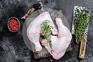 Fresh raw chicken legs on a cutting board. Black background. Top view