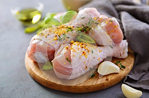 Fresh raw chicken legs with spices - salt, pepper, olive oil and garlic.