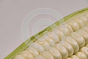 Fresh corn cob in a container on a white background