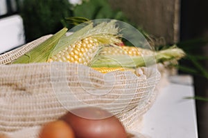 Fresh raw corn in eco canvas grocery bag. Cotton bags with vegetables. Zero waste shopping concept. Plastic free items