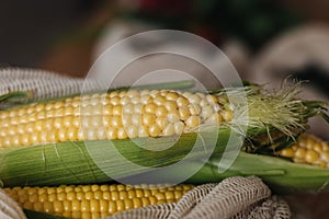 Fresh raw corn in eco canvas grocery bag. Cotton bags on wooden table. Zero waste shopping concept. Plastic free items