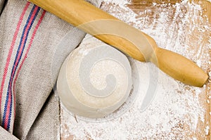 Fresh raw dough and rolling pin