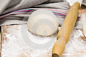 Fresh raw dough and rolling pin